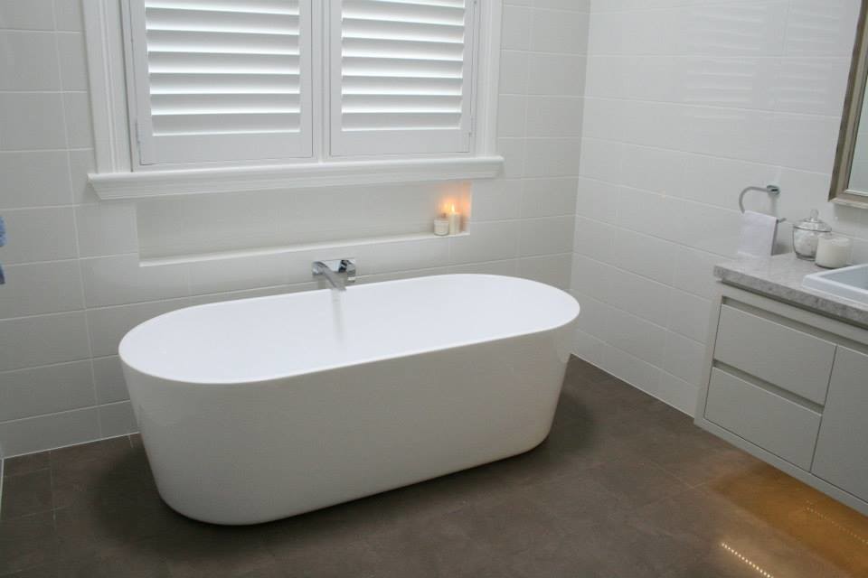 Inspiration for a large contemporary master bathroom in Sydney with flat-panel cabinets, white cabinets, a freestanding tub, an open shower, a wall-mount toilet, white tile, ceramic tile, white walls, a drop-in sink and engineered quartz benchtops.