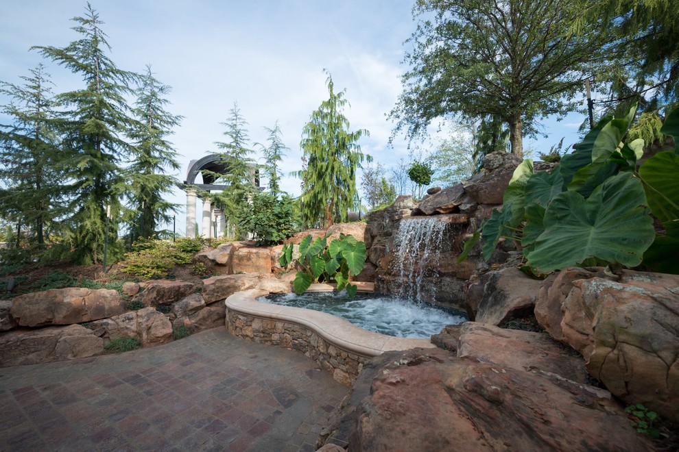 Design ideas for a mid-sized transitional backyard garden in Oklahoma City with a water feature and natural stone pavers.