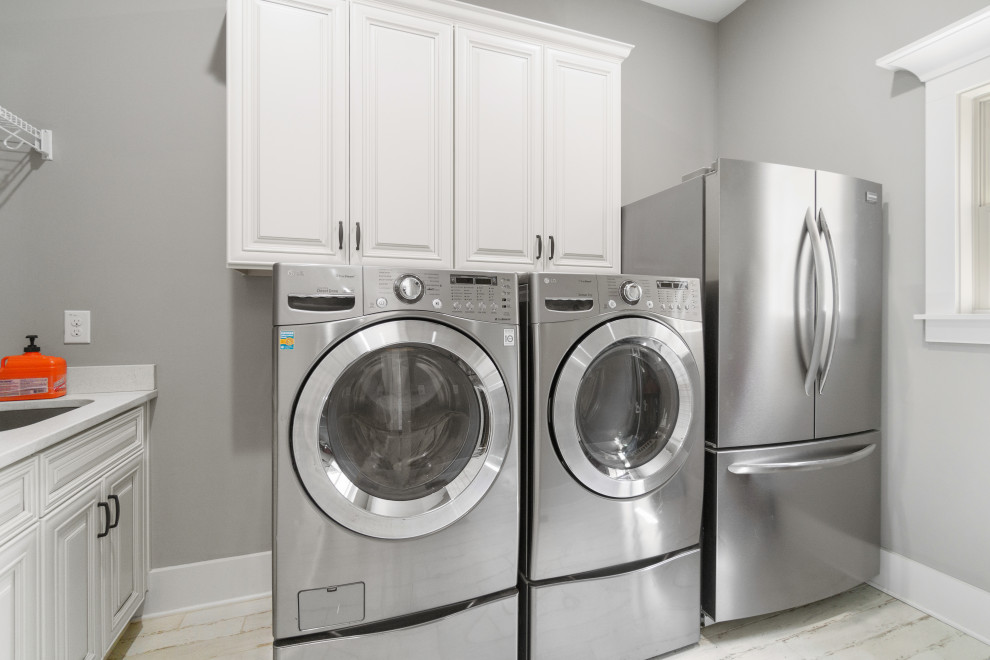 Photo of a large country single-wall utility room in Atlanta with a drop-in sink, beaded inset cabinets, white cabinets, granite benchtops, grey walls, painted wood floors, a side-by-side washer and dryer, white floor and white benchtop.