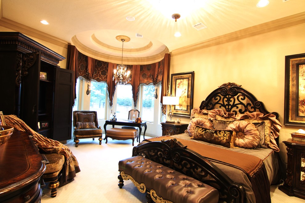 This is an example of a large mediterranean master bedroom in Houston with beige walls and carpet.