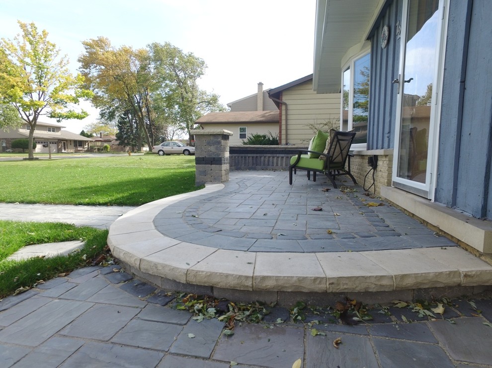Mid-sized traditional front yard patio in Chicago with natural stone pavers and a roof extension.
