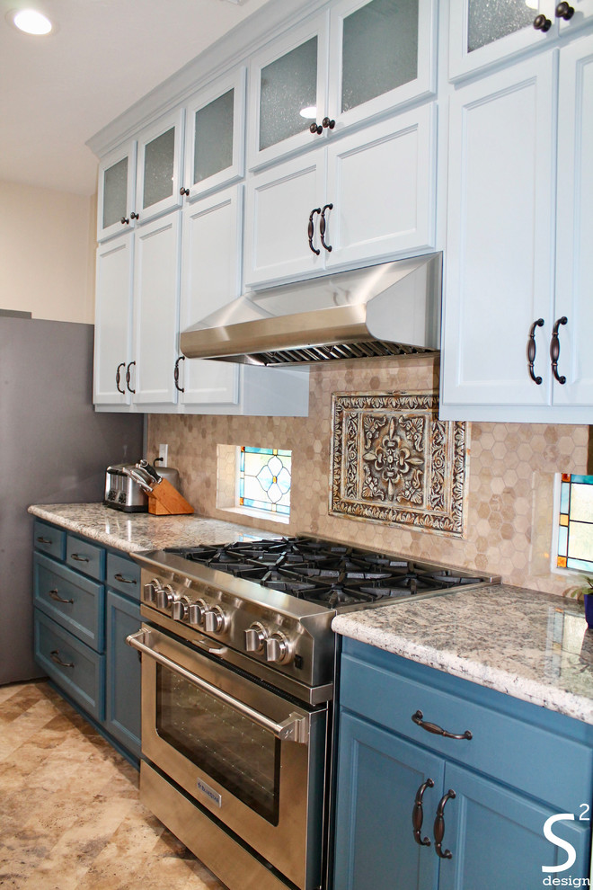 Inspiration for a mid-sized eclectic eat-in kitchen in Houston with an undermount sink, recessed-panel cabinets, blue cabinets, granite benchtops, beige splashback, travertine splashback, stainless steel appliances, vinyl floors, with island, beige floor and multi-coloured benchtop.