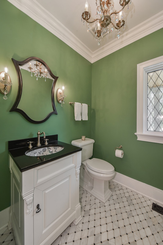 Design ideas for a small arts and crafts powder room in Chicago with raised-panel cabinets, white cabinets, a two-piece toilet, green walls, marble floors, an undermount sink, granite benchtops and black benchtops.