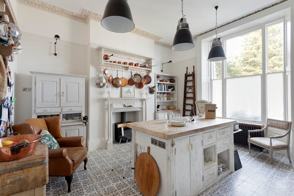 Foto di un cucina con isola centrale shabby-chic style con top in legno