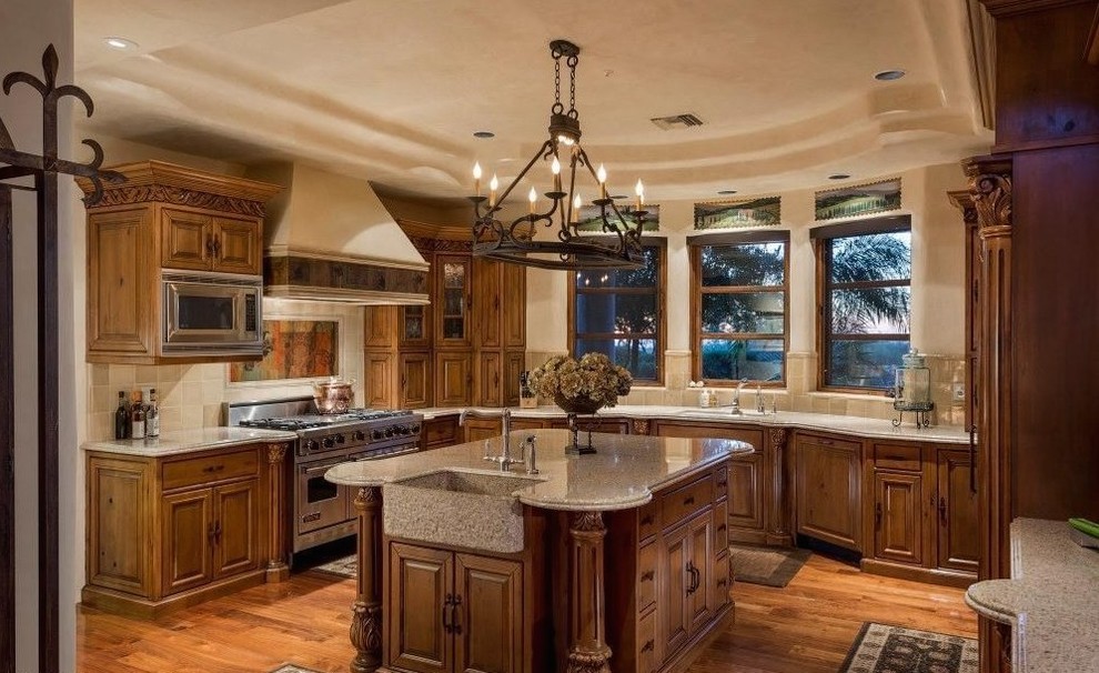 Eat-in kitchen - huge transitional u-shaped medium tone wood floor eat-in kitchen idea in Phoenix with a drop-in sink, raised-panel cabinets, medium tone wood cabinets, granite countertops, beige backsplash, stone tile backsplash, stainless steel appliances and an island