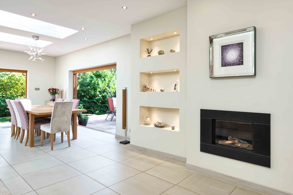 Photo of a large traditional open plan dining in Hertfordshire with white walls, ceramic floors, a ribbon fireplace and a metal fireplace surround.