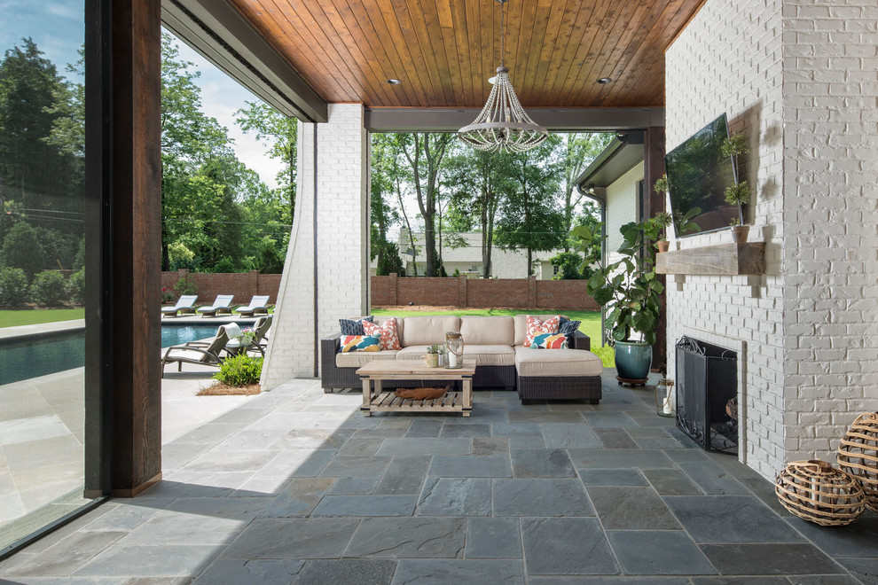 Inspiration for a mid-sized country backyard patio in Charlotte with a roof extension and tile.