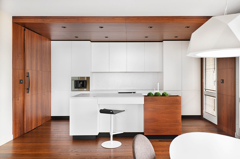 This is an example of a contemporary kitchen in Other with flat-panel cabinets, white cabinets, white splashback, panelled appliances, dark hardwood floors and with island.