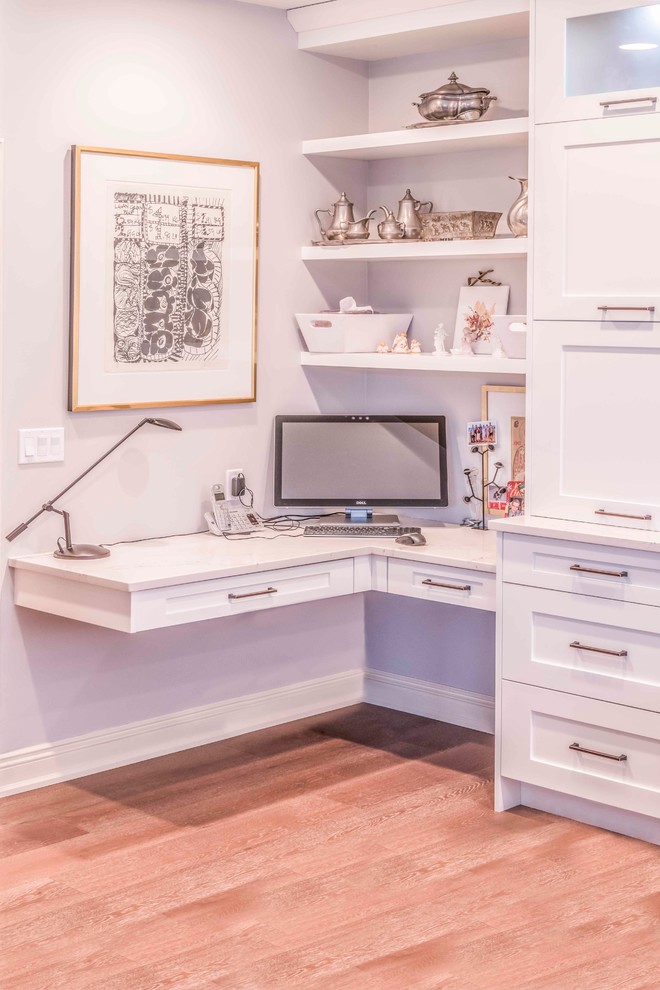 Example of a mid-sized transitional u-shaped medium tone wood floor and brown floor kitchen design in Calgary with an undermount sink, flat-panel cabinets, white cabinets, marble countertops, gray backsplash, ceramic backsplash, paneled appliances and an island