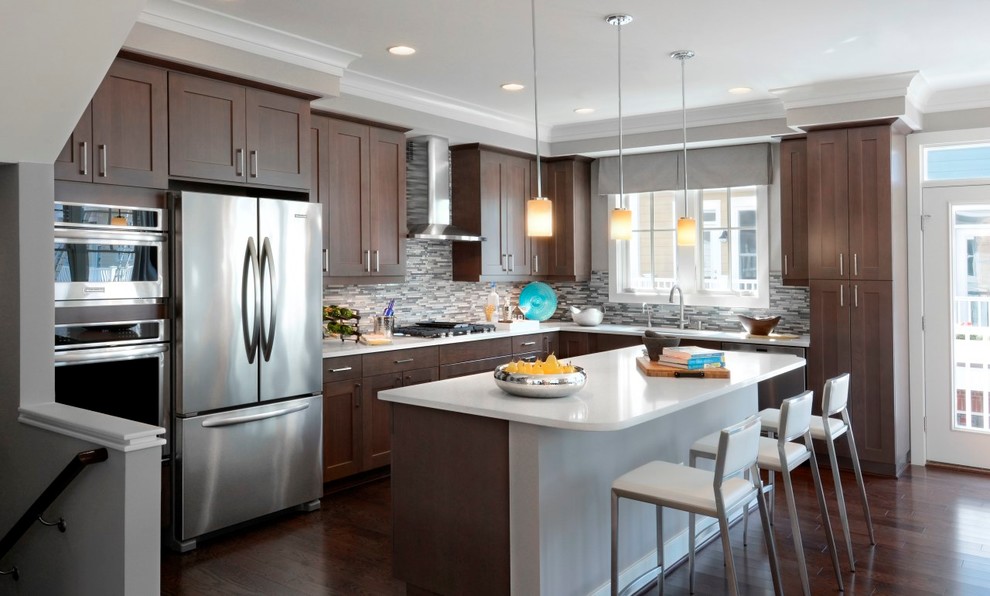 Design ideas for a contemporary l-shaped eat-in kitchen in DC Metro with an undermount sink, shaker cabinets, medium wood cabinets, quartz benchtops, metallic splashback, ceramic splashback, stainless steel appliances, dark hardwood floors and with island.