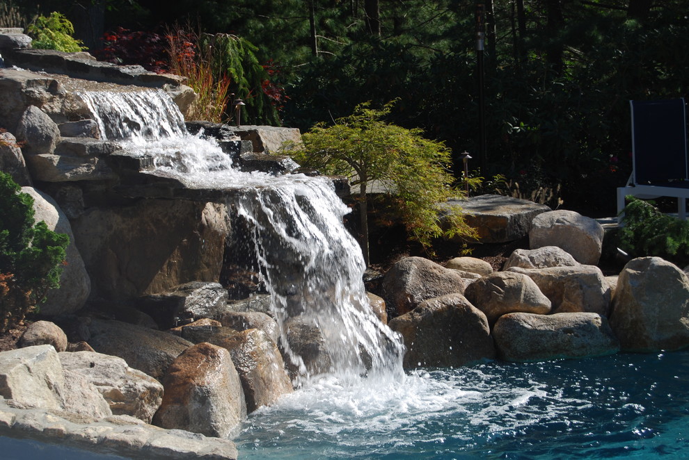 Water slide - mid-sized rustic backyard stone and kidney-shaped natural water slide idea in Boston