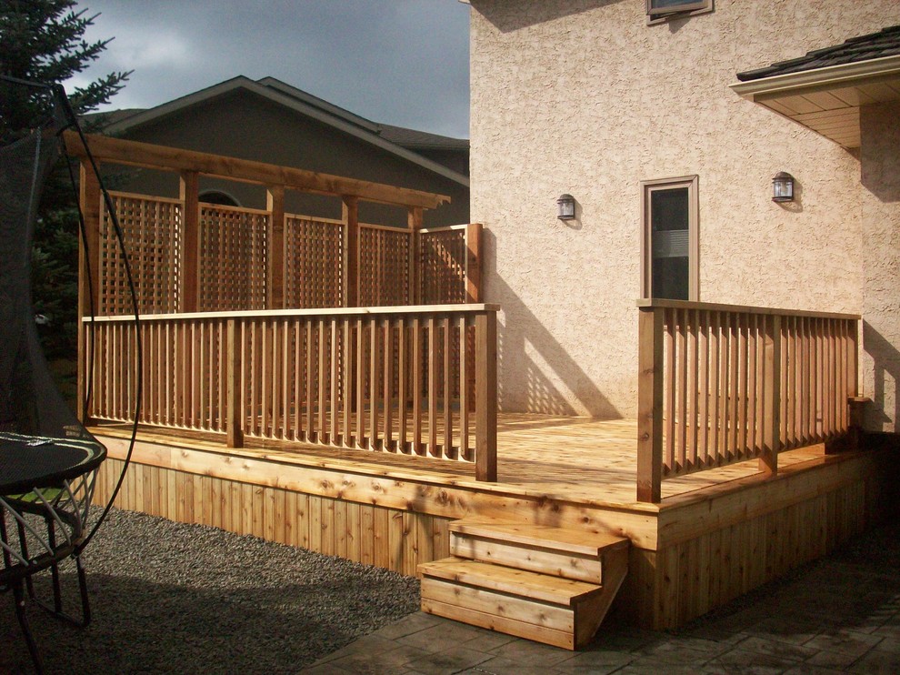 This is an example of a large traditional backyard deck in Calgary with no cover.