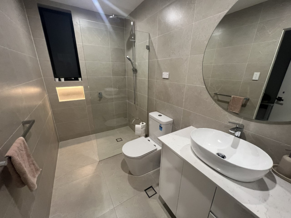 Inspiration for a mid-sized modern master bathroom in Sydney with beaded inset cabinets, white cabinets, an open shower, a one-piece toilet, beige tile, ceramic tile, beige walls, ceramic floors, a vessel sink, quartzite benchtops, beige floor, white benchtops, a single vanity, a freestanding vanity and recessed.