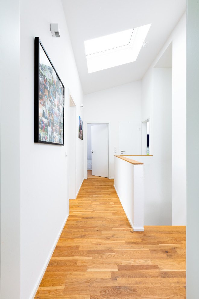 Hallway - contemporary light wood floor hallway idea in Dusseldorf with white walls