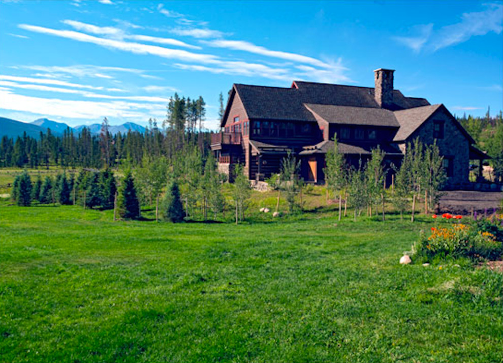 Design ideas for a mid-sized rustic full sun backyard stone landscaping in Denver for summer.