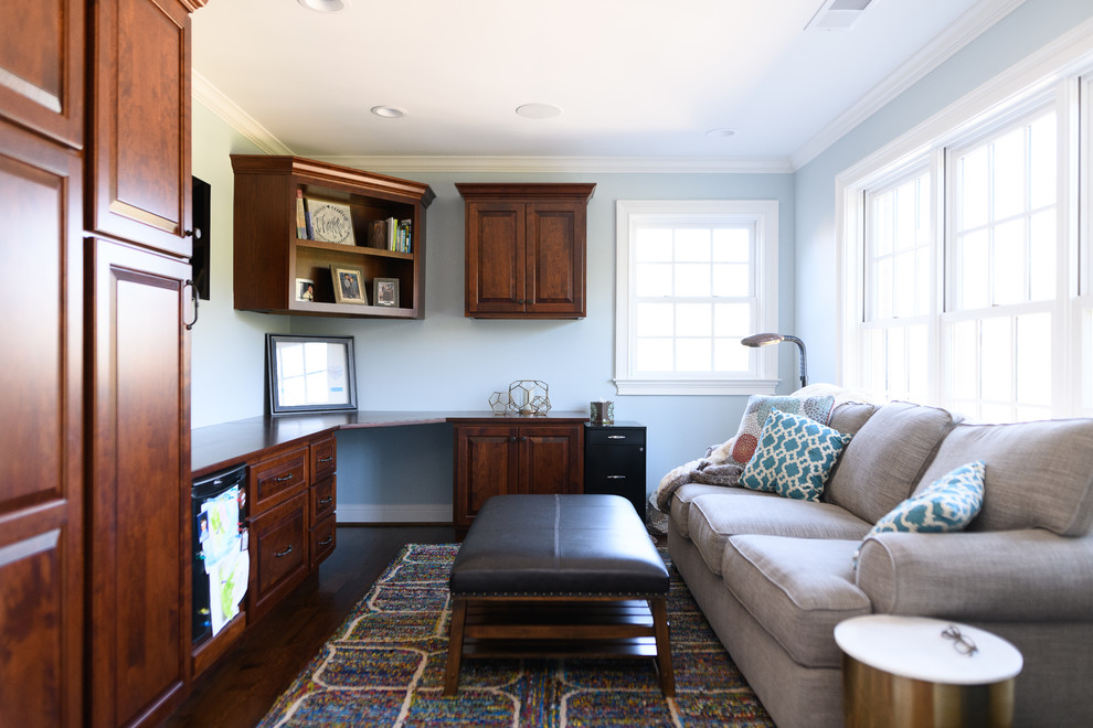 This is an example of a mid-sized transitional home office in Other with blue walls, dark hardwood floors, no fireplace, a built-in desk and brown floor.