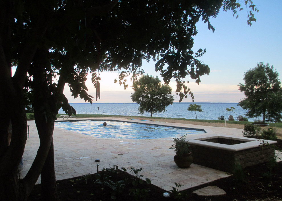 Example of a mid-sized backyard brick and custom-shaped lap pool fountain design in Baltimore