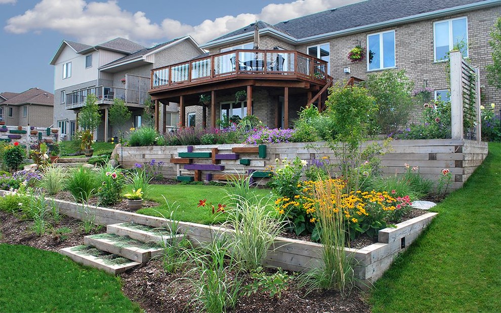 Inspiration for a large contemporary backyard full sun garden for spring in Toronto with a retaining wall.