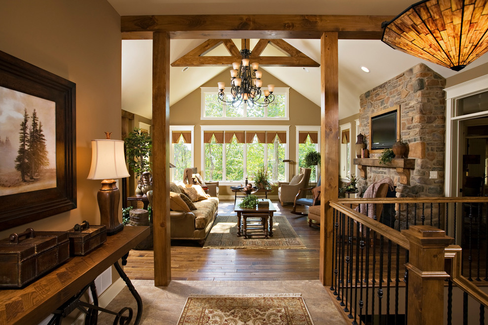 Example of a large mountain style medium tone wood floor foyer design with beige walls