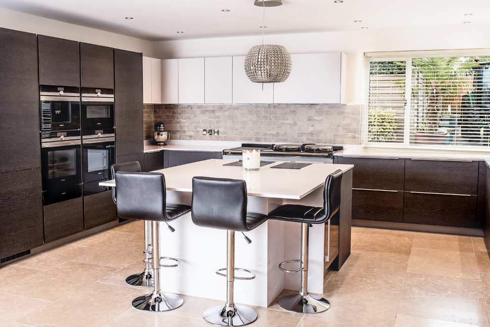 Photo of a mid-sized contemporary l-shaped open plan kitchen in Other with a single-bowl sink, flat-panel cabinets, medium wood cabinets, quartzite benchtops, beige splashback, stone tile splashback, black appliances, porcelain floors, with island, beige floor and white benchtop.