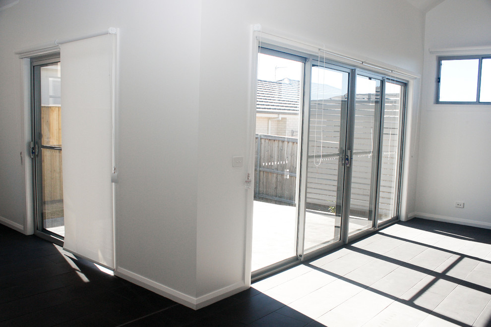 Design ideas for a mid-sized contemporary open concept living room in Newcastle - Maitland with white walls, ceramic floors, no fireplace, a freestanding tv and black floor.
