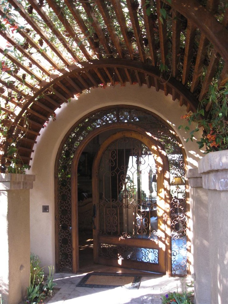 Large mediterranean front door in Phoenix with brick floors, a single front door, a metal front door and brown floor.