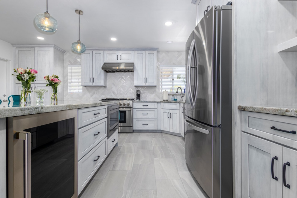 Transitional l-shaped kitchen photo in Phoenix with a single-bowl sink, shaker cabinets, white cabinets, granite countertops, white backsplash and stainless steel appliances