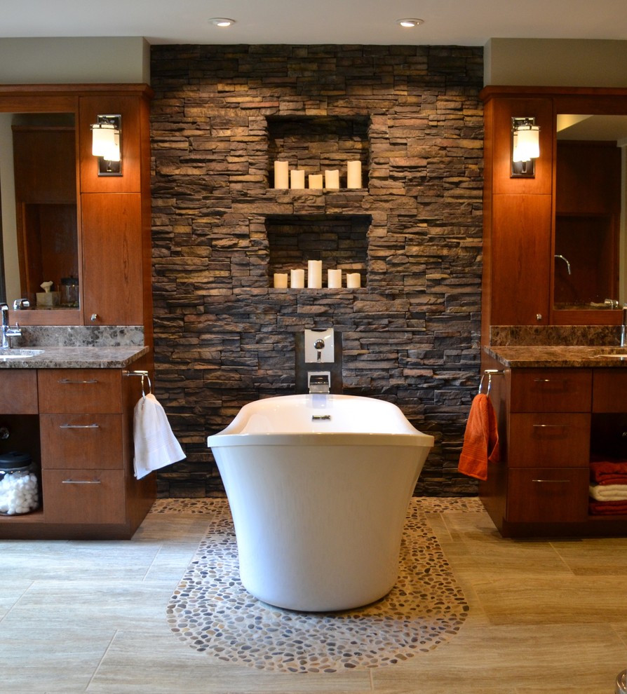 Contemporary bathroom in Cedar Rapids with flat-panel cabinets, dark wood cabinets, a freestanding tub and pebble tile floors.