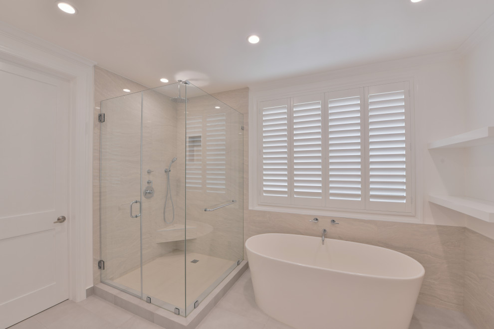 Inspiration for a medium sized classic ensuite bathroom in Los Angeles with shaker cabinets, white cabinets, a freestanding bath, a corner shower, a wall mounted toilet, white tiles, marble tiles, white walls, porcelain flooring, granite worktops, white floors, white worktops, an enclosed toilet, double sinks, a built in vanity unit and a vaulted ceiling.
