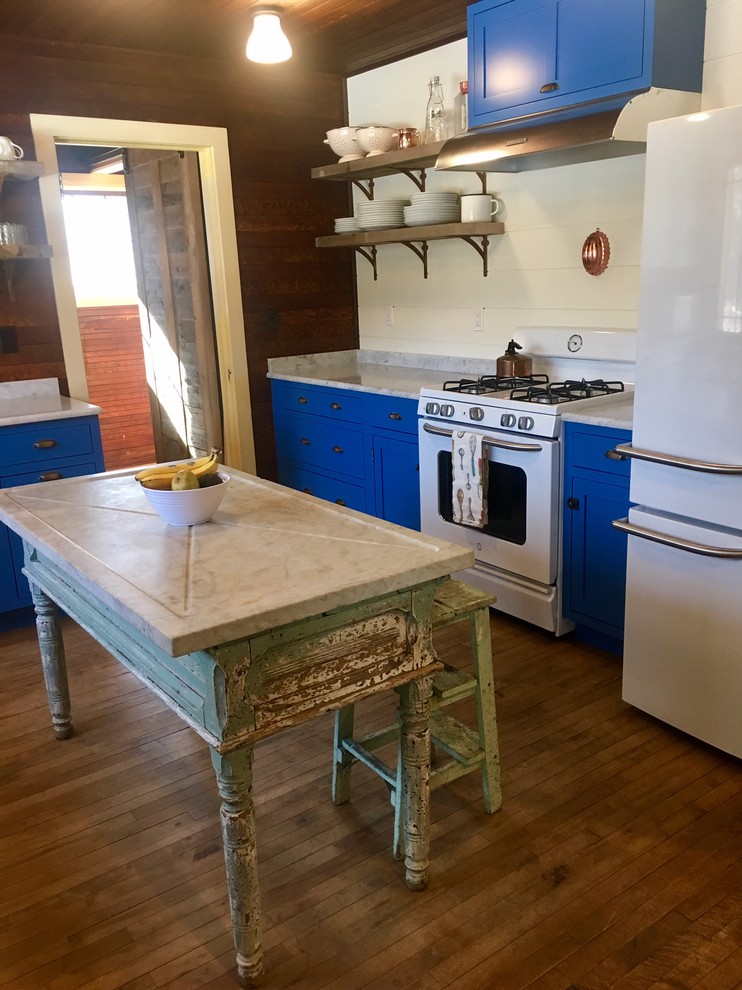 Inspiration for a rustic kitchen remodel with blue cabinets, white appliances and an island