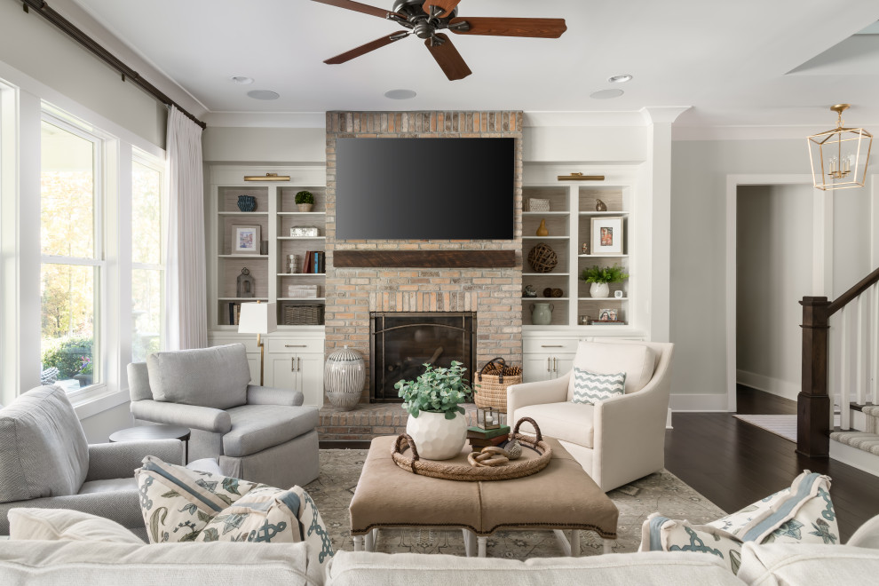 Example of a transitional open concept dark wood floor and brown floor living room design in Atlanta with gray walls, a standard fireplace, a brick fireplace and a wall-mounted tv