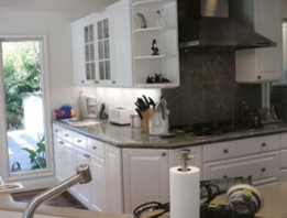 Mid-sized transitional medium tone wood floor open concept kitchen photo in Orange County with a double-bowl sink, raised-panel cabinets, white cabinets, granite countertops, stone slab backsplash, stainless steel appliances and an island