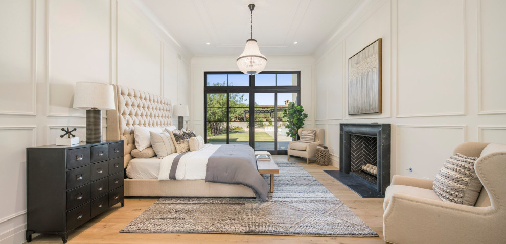 Photo of a large modern master bedroom in Phoenix with white walls, light hardwood floors, a standard fireplace, a concrete fireplace surround and recessed.