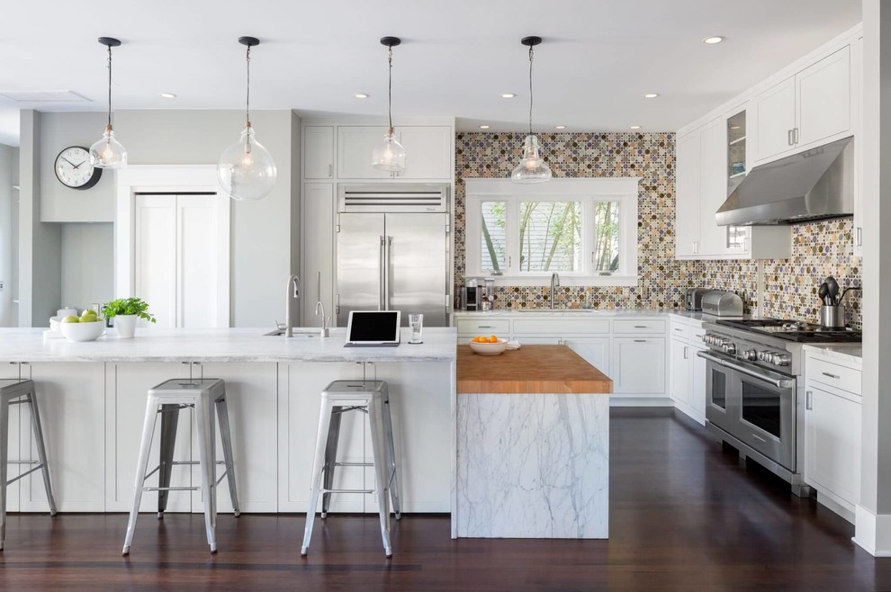 Design ideas for a transitional l-shaped kitchen in Austin with an undermount sink, shaker cabinets, white cabinets, marble benchtops, multi-coloured splashback, stainless steel appliances, dark hardwood floors, with island, brown floor and white benchtop.