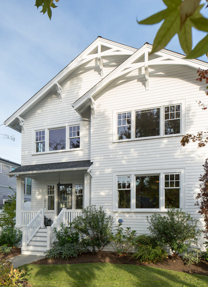 This is an example of a large traditional three-storey white exterior in Seattle with wood siding.