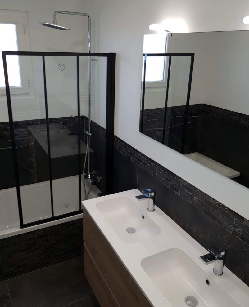 Inspiration for a medium sized contemporary grey and black bathroom in Other with a submerged bath, a shower/bath combination, black tiles, cement tiles, black walls, cement flooring, a submerged sink, black floors, a hinged door and black worktops.