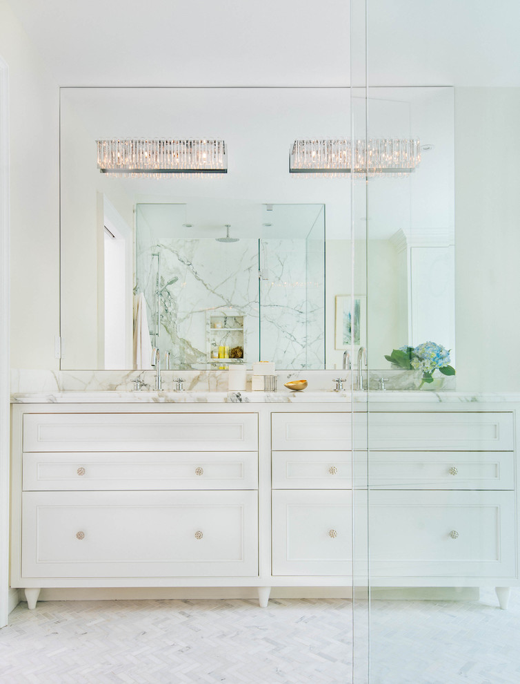 Large transitional master bathroom in Toronto with an undermount sink, beaded inset cabinets, white cabinets, marble benchtops, a freestanding tub, a corner shower, a one-piece toilet, white tile, stone tile, white walls, marble floors, white floor and a hinged shower door.