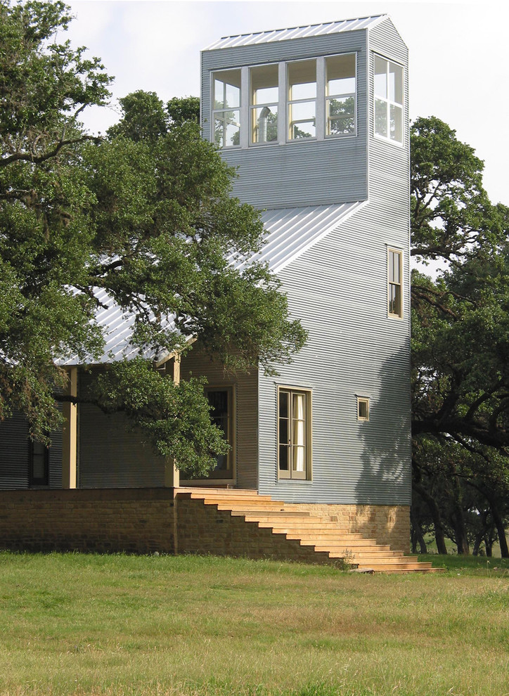 This is an example of a large contemporary three-storey grey exterior in Austin with metal siding.