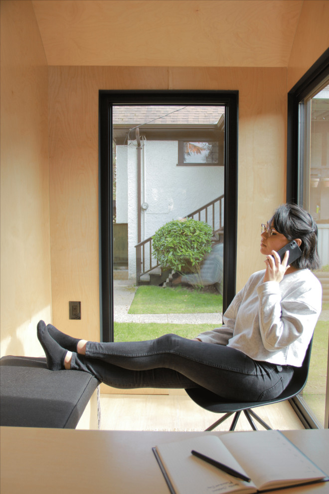Kleines Modernes Arbeitszimmer mit Arbeitsplatz, brauner Wandfarbe, Vinylboden, Einbau-Schreibtisch, braunem Boden, gewölbter Decke und Holzwänden in Vancouver