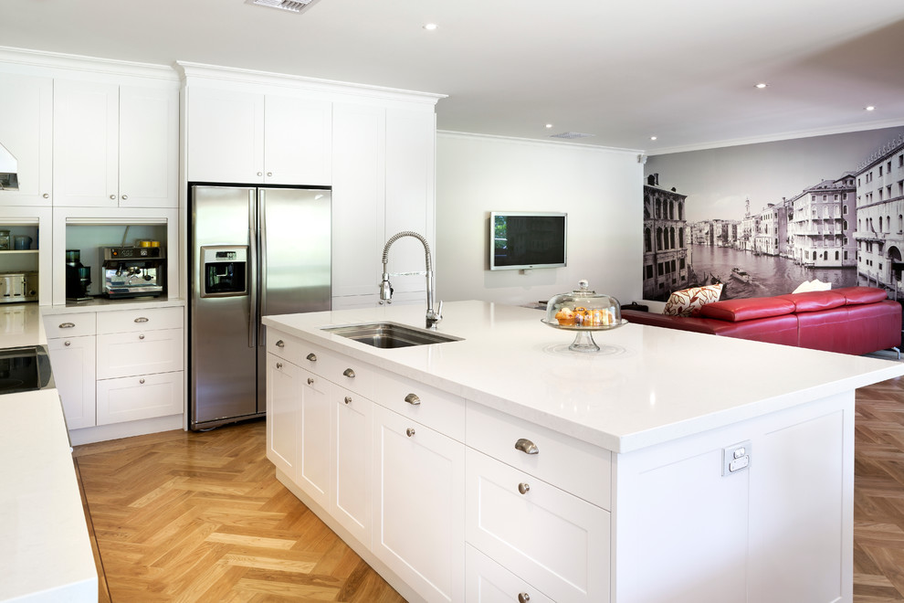 Photo of a transitional open plan kitchen in Melbourne with white cabinets, stainless steel appliances, shaker cabinets and an undermount sink.