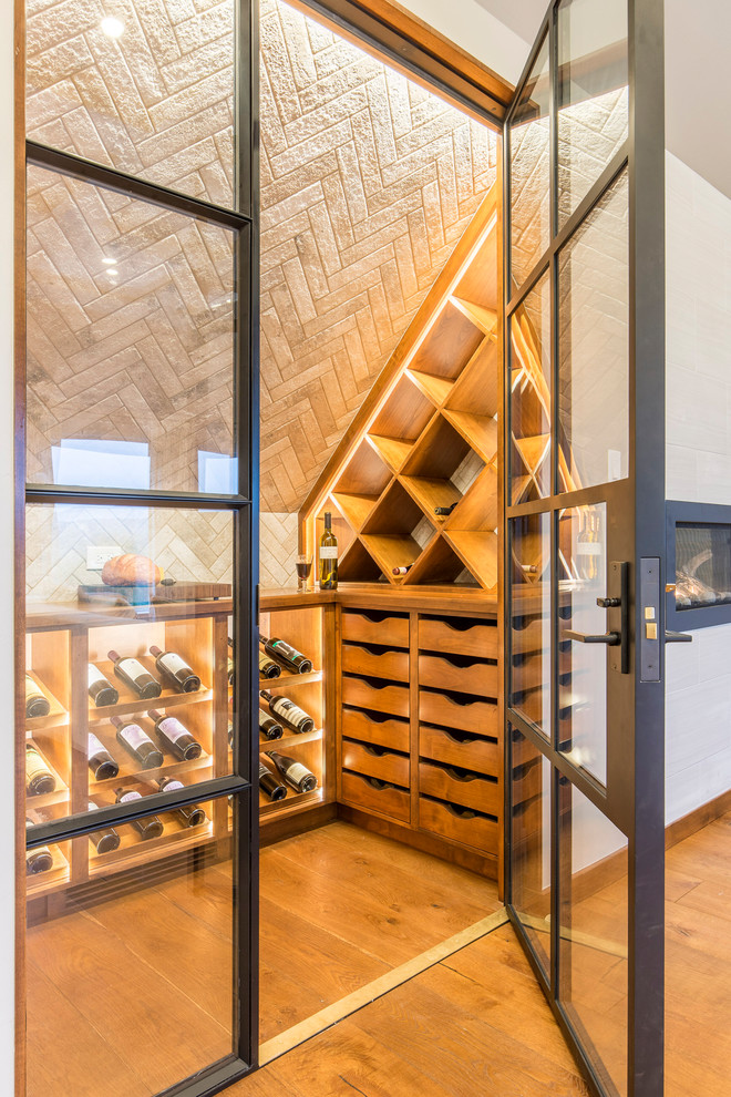 Wine cellar - mid-sized contemporary medium tone wood floor wine cellar idea in Austin