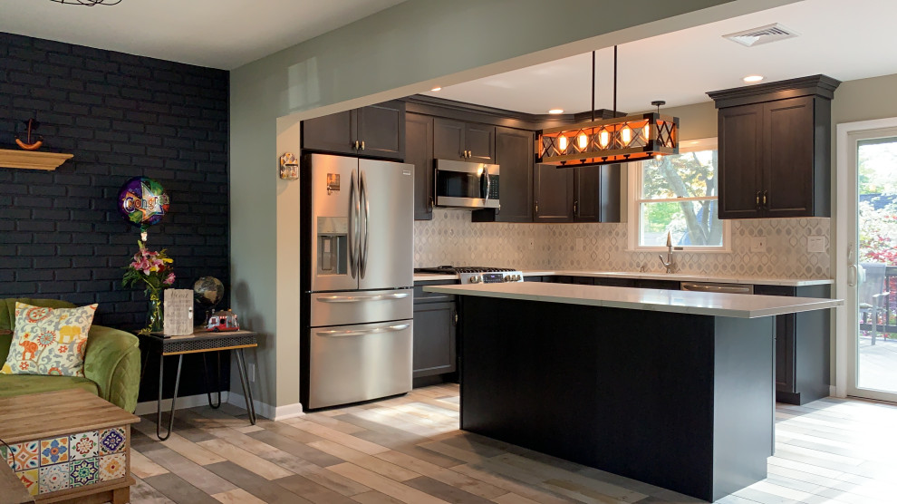 Mid-sized modern l-shaped eat-in kitchen in Newark with an undermount sink, shaker cabinets, dark wood cabinets, quartzite benchtops, grey splashback, stainless steel appliances, porcelain floors, with island, grey floor and white benchtop.