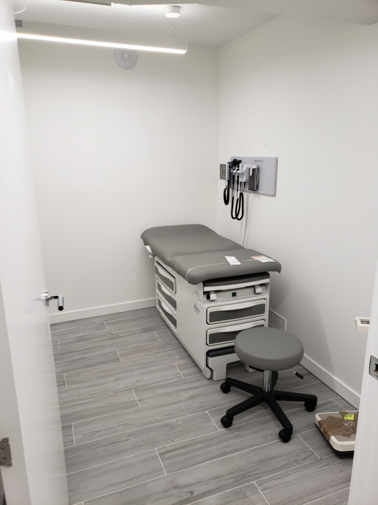 Diseño de despacho minimalista grande con paredes blancas, suelo de baldosas de porcelana, escritorio empotrado y suelo multicolor
