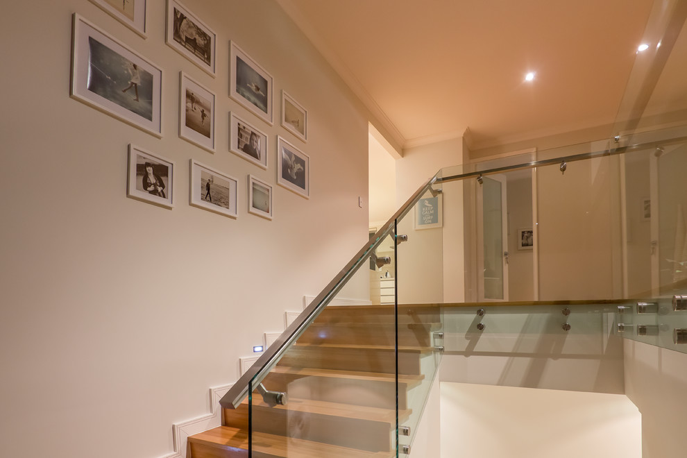 Inspiration for a small contemporary wood straight staircase in Perth with wood risers and metal railing.