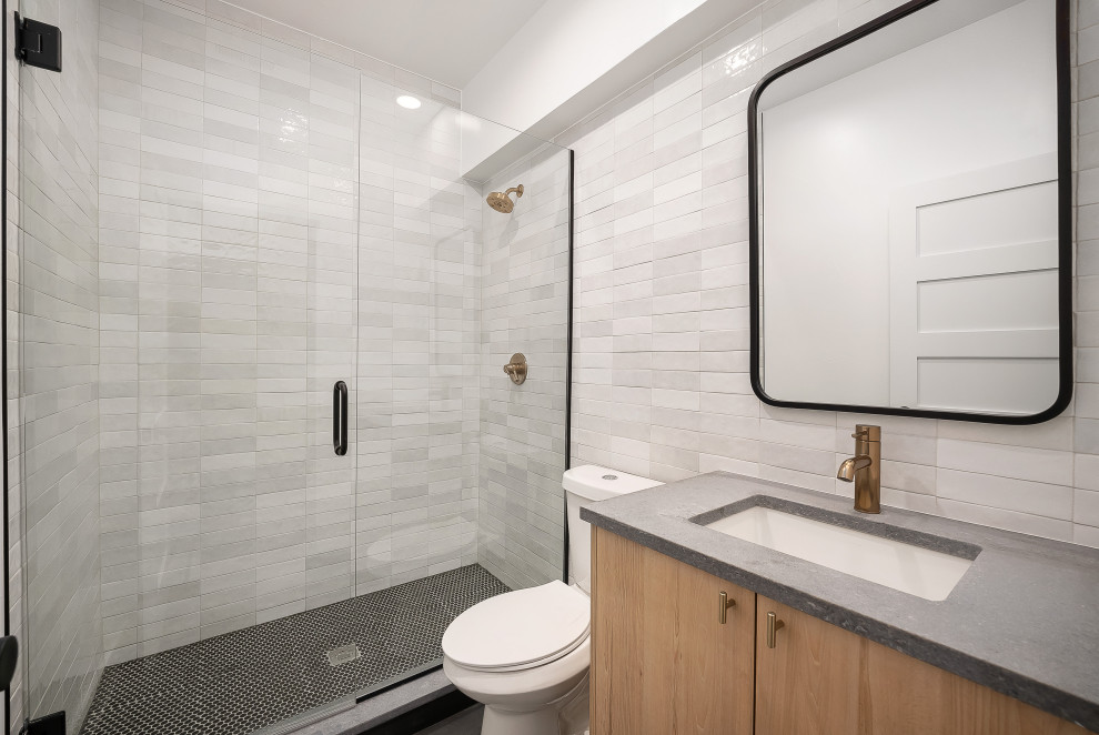 Inspiration for a small industrial 3/4 gray tile and ceramic tile ceramic tile, black floor and single-sink bathroom remodel in Denver with flat-panel cabinets, light wood cabinets, a two-piece toilet, white walls, an undermount sink, quartz countertops, a hinged shower door, gray countertops and a floating vanity