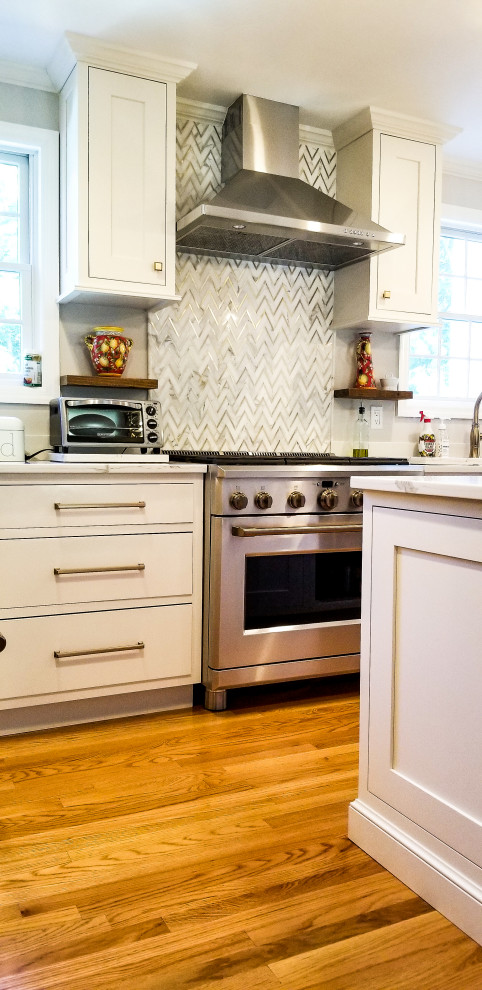 Inredning av ett klassiskt vit vitt kök, med en rustik diskho, skåp i shakerstil, vita skåp, bänkskiva i kvarts, mellanmörkt trägolv och en köksö