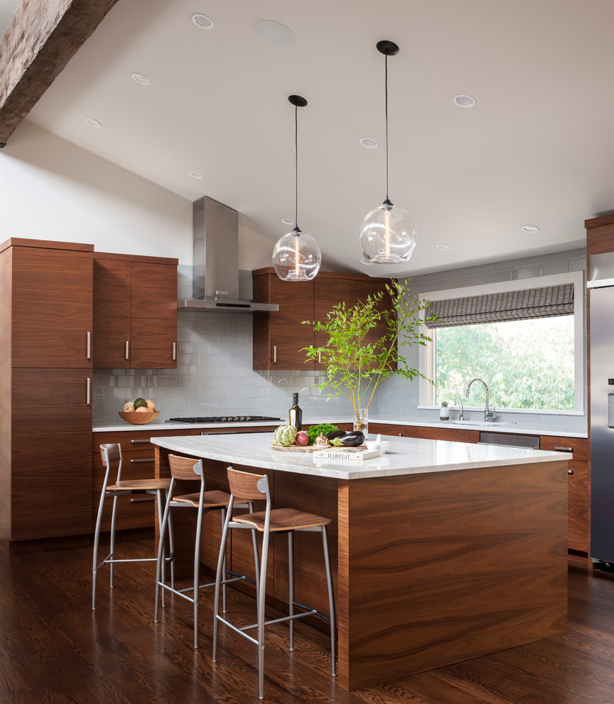 Inspiration for an expansive midcentury l-shaped eat-in kitchen in Seattle with an undermount sink, flat-panel cabinets, dark wood cabinets, marble benchtops, grey splashback, glass tile splashback, stainless steel appliances, dark hardwood floors and with island.