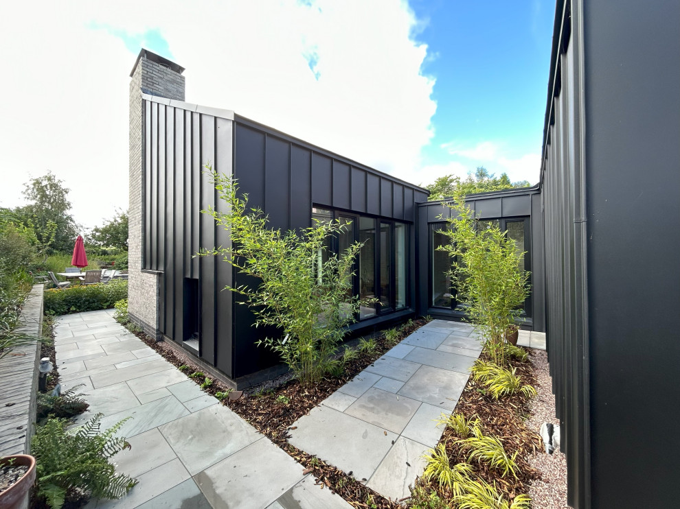 Mittelgroße, Zweistöckige Moderne Doppelhaushälfte mit Metallfassade, Schmetterlingsdach, Blechdach und schwarzem Dach in West Midlands