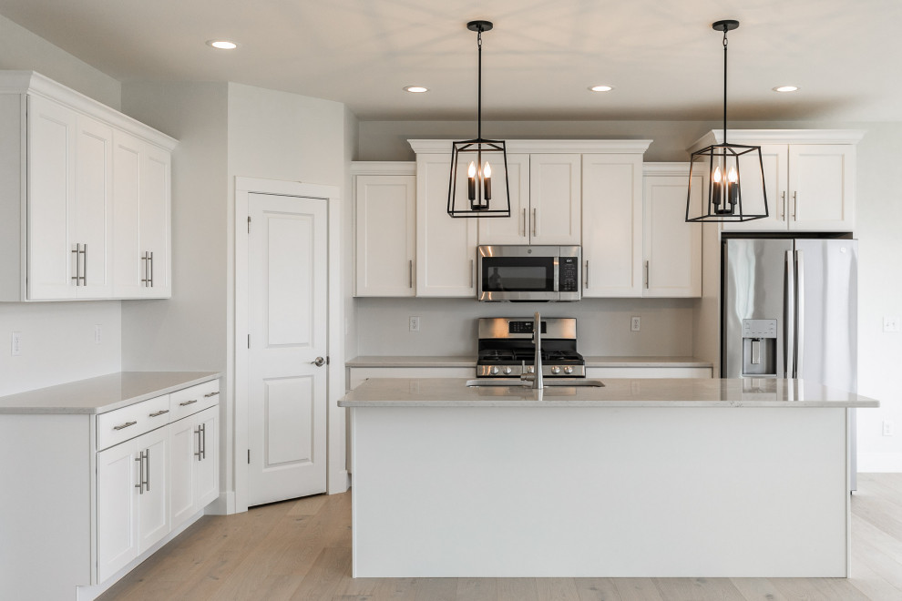Example of a trendy galley open concept kitchen design in Cedar Rapids with white cabinets and an island