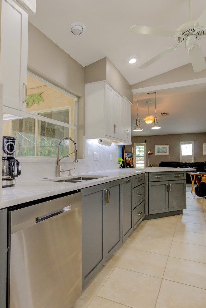 Inspiration for a mid-sized contemporary galley kitchen pantry remodel with an undermount sink, shaker cabinets, white cabinets, quartz countertops, white backsplash, stone slab backsplash, stainless steel appliances, a peninsula and white countertops